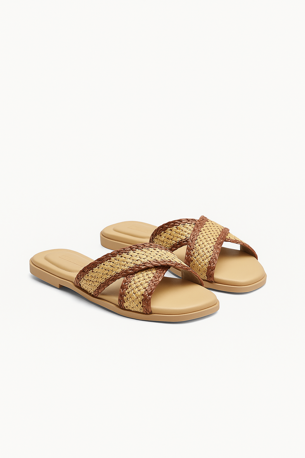 Pair of beige sandals with woven brown straps on a white background